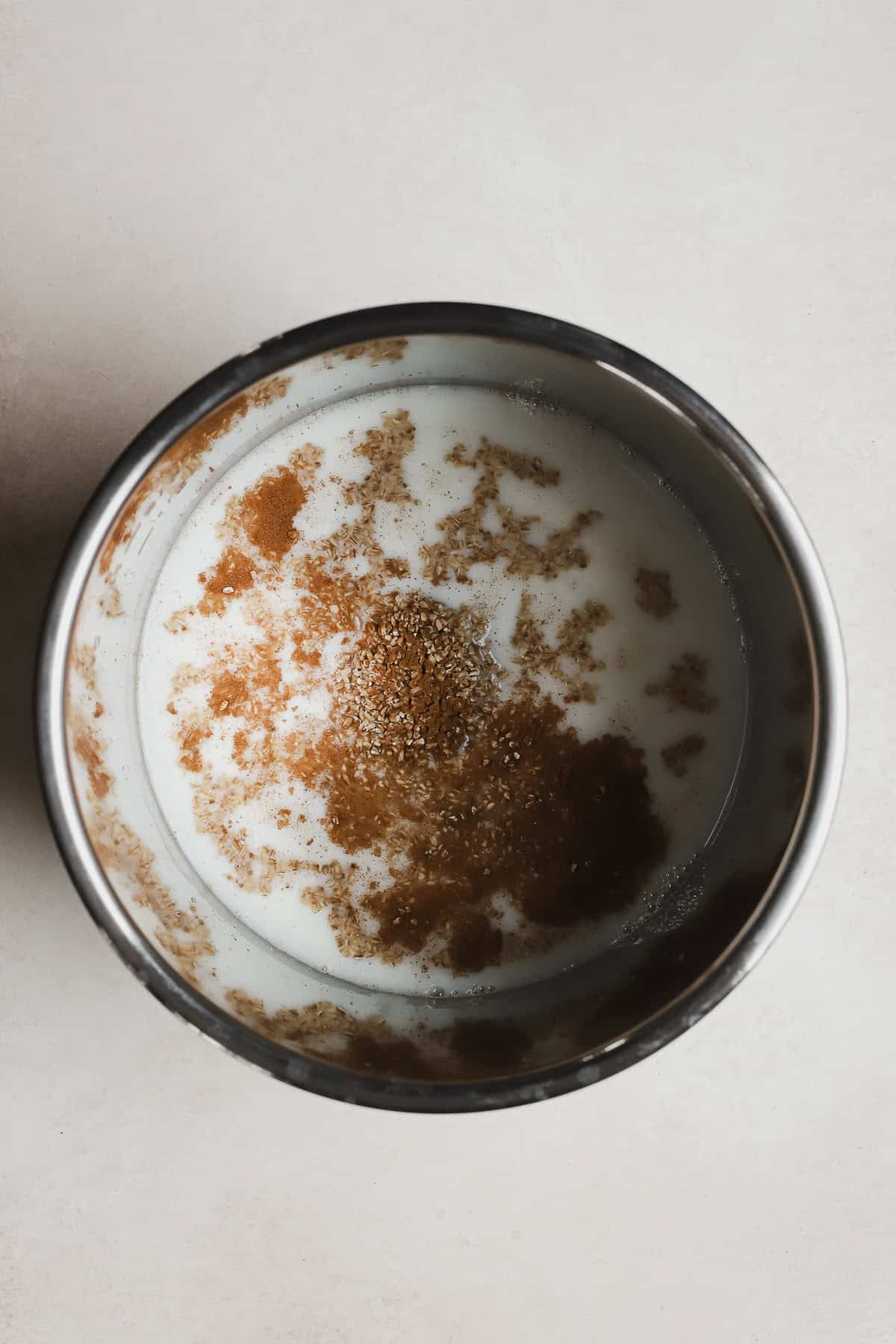 Steel cut oats ingredients in Instant Pot base bowl.