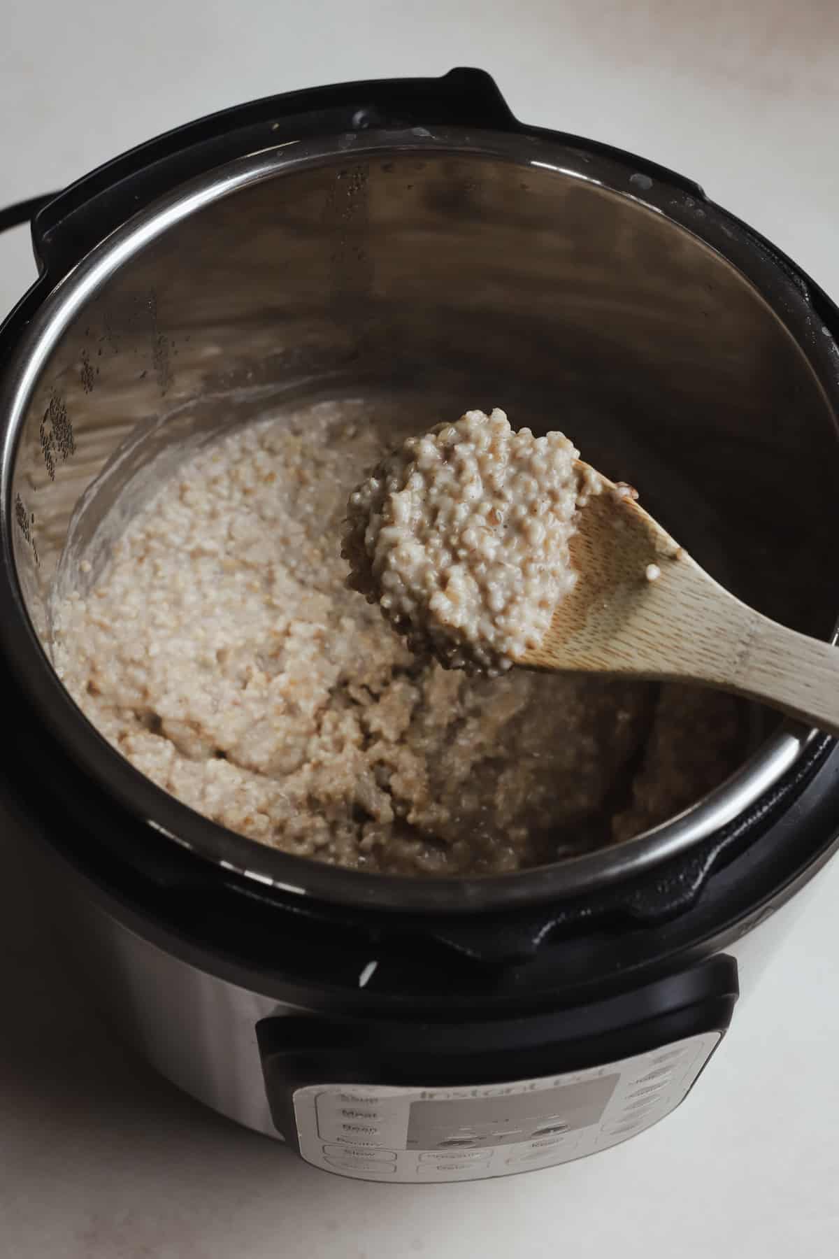 Spoonful of steel cut oats being scooped up from Instant Pot.