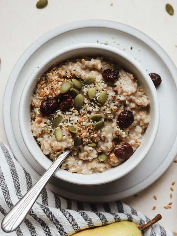 Small bowl of Instant Pot steel cut oats with spoon and toppings.