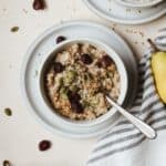 Small bowl of Instant Pot steel cut oats with spoon and toppings.