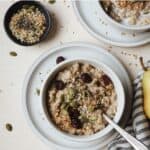 Small bowl of Instant Pot steel cut oats with spoon and toppings.
