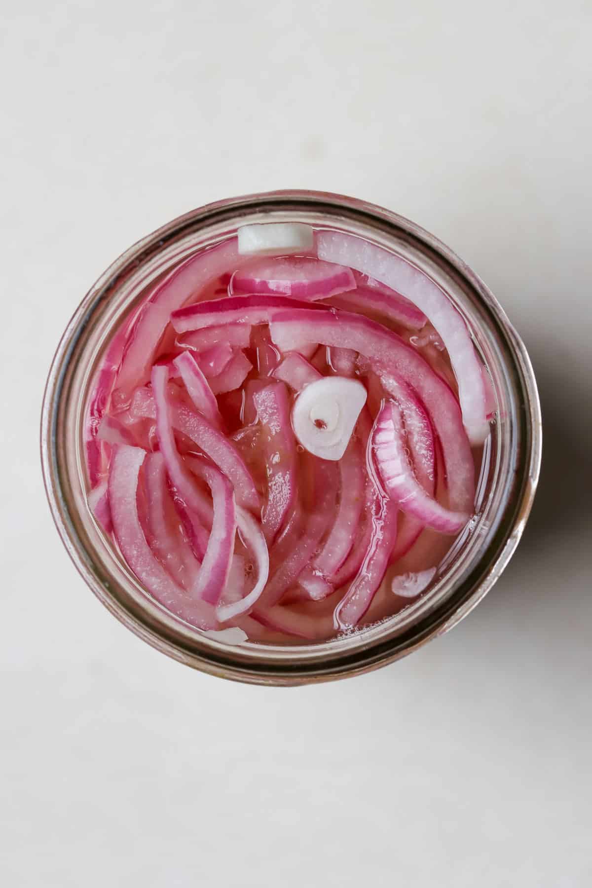 Pickled red onions in glass jar.