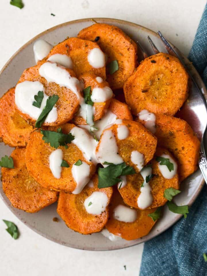 Moroccan-spiced roasted carrots with tahini sauce drizzled over the top.