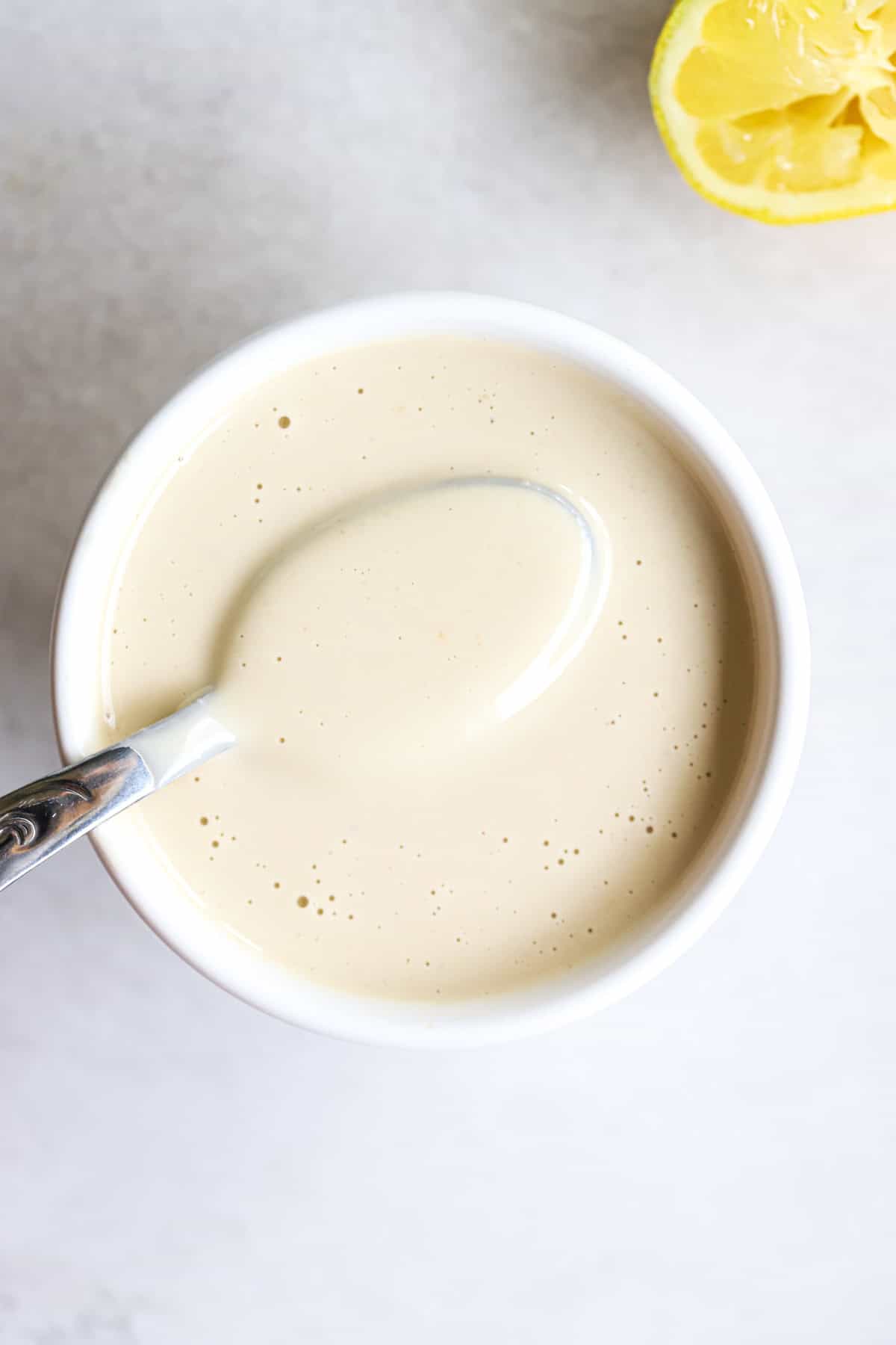 Tahini sauce in small white bowl.