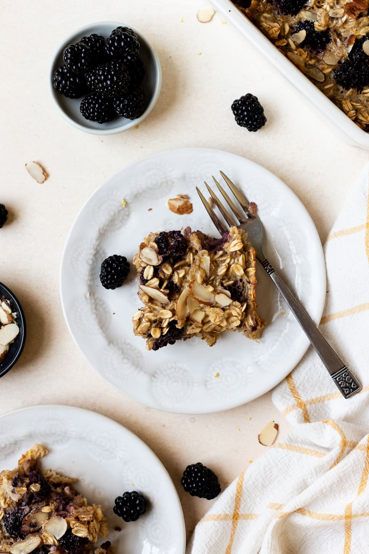 Slice of blackberry baked oatmeal on small plate with fork.