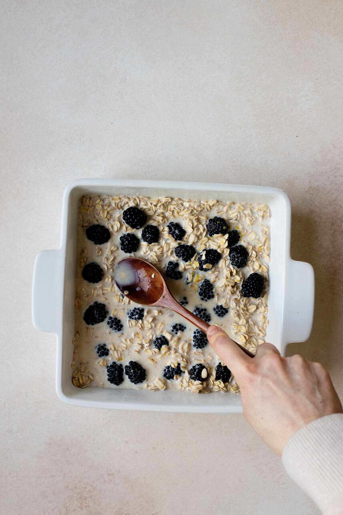 Stirring and smooshing blackberries into oat mixture.