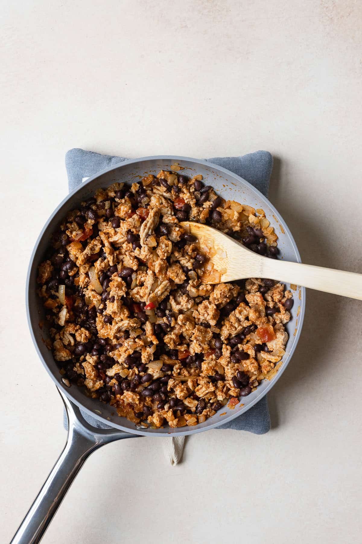Ground chicken taco meat with black beans in a skillet.
