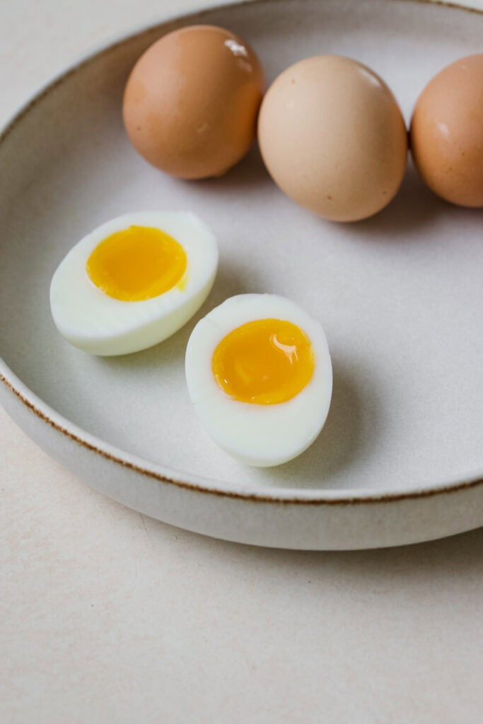 Jammy eggs in white bowl.