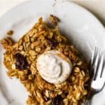 Slice of carrot cake baked oatmeal on a small plate with fork.