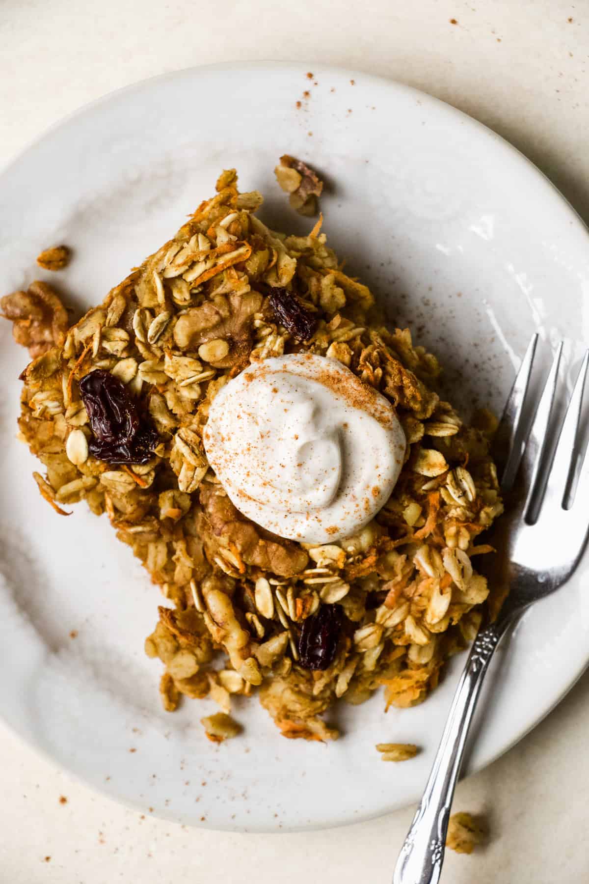 Slice of carrot cake baked oatmeal on a small plate with fork.