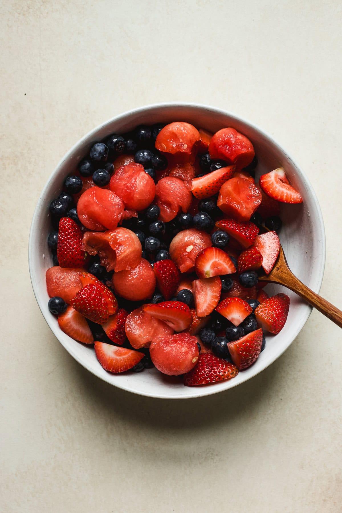 Watermelon, blueberries, and quartered strawberries in a bowl.