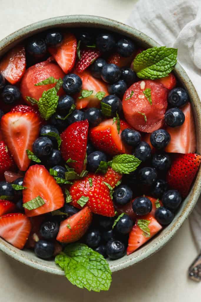Watermelon fruit salad with lime and mint in a bowl garnished with fresh mint leaves.