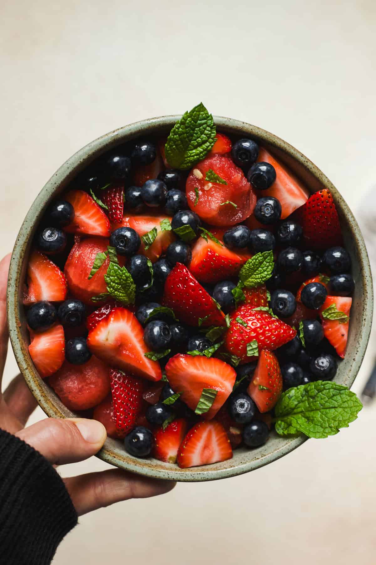 Watermelon fruit salad with lime in a bowl garnished with fresh mint leaves.