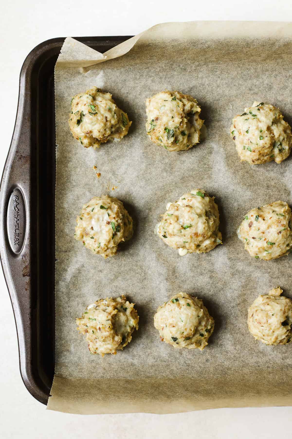 Herby baked chicken meatballs on sheet pan.