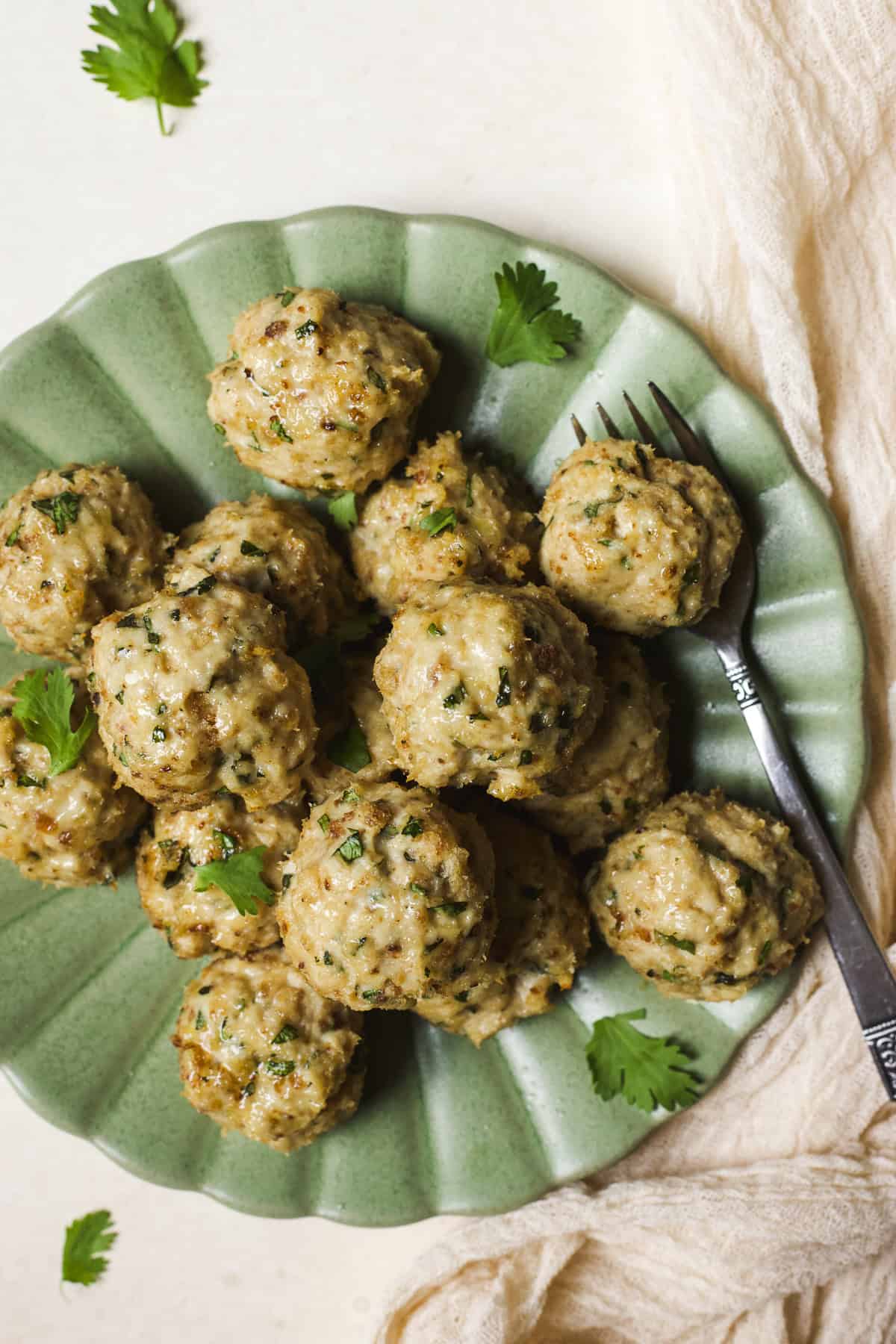 Herby baked chicken meatballs on a plate.
