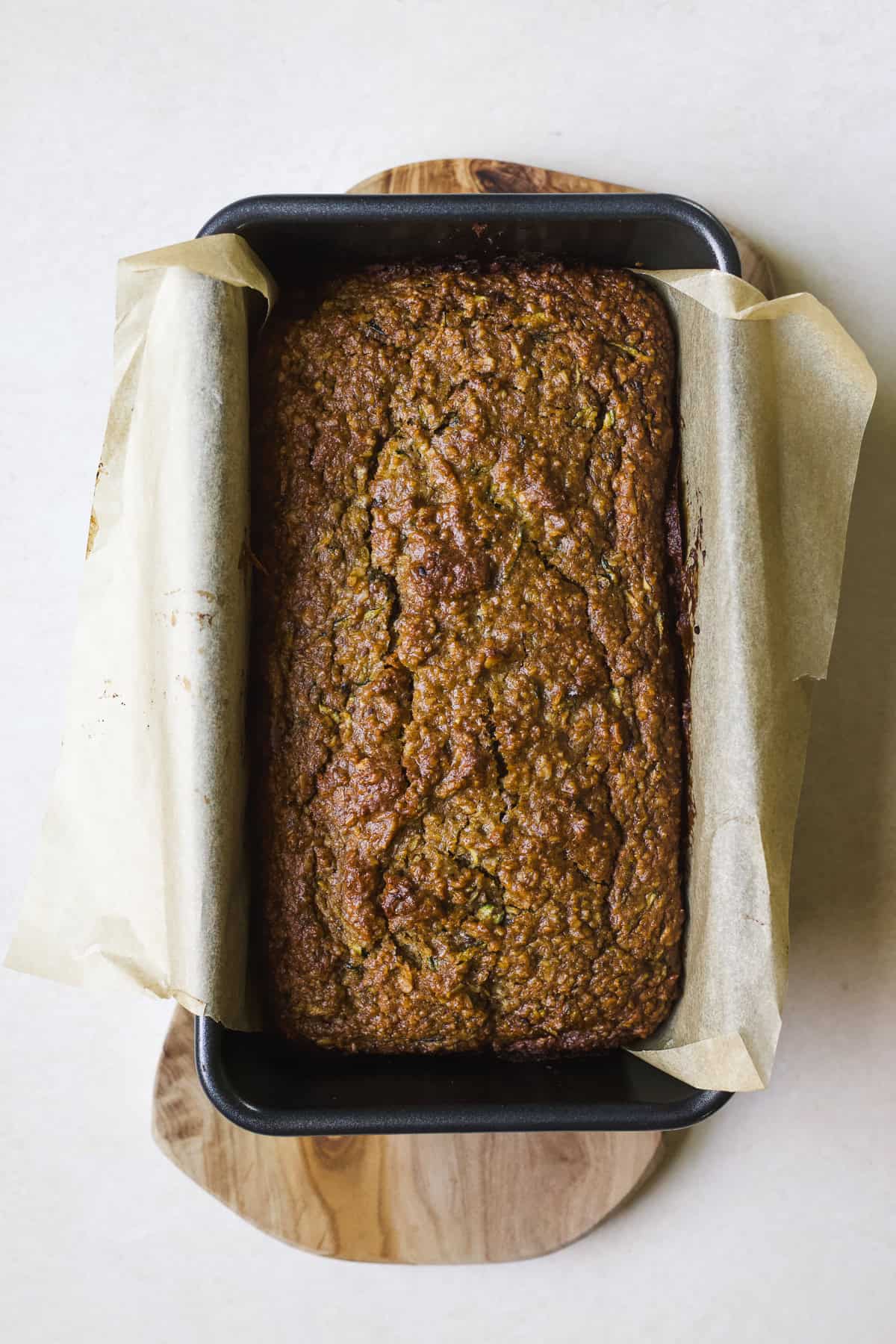 Baked zucchini bread loaf in loaf pan.
