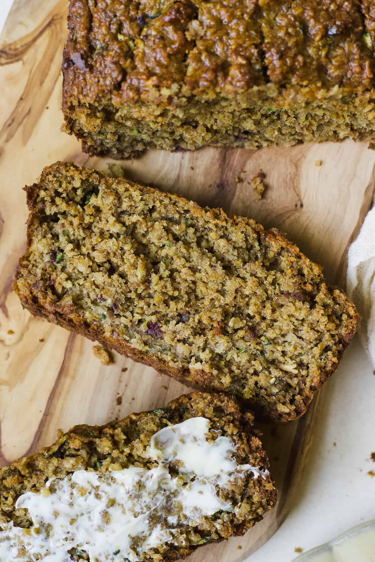 Slice of oat zucchini bread on cutting board.