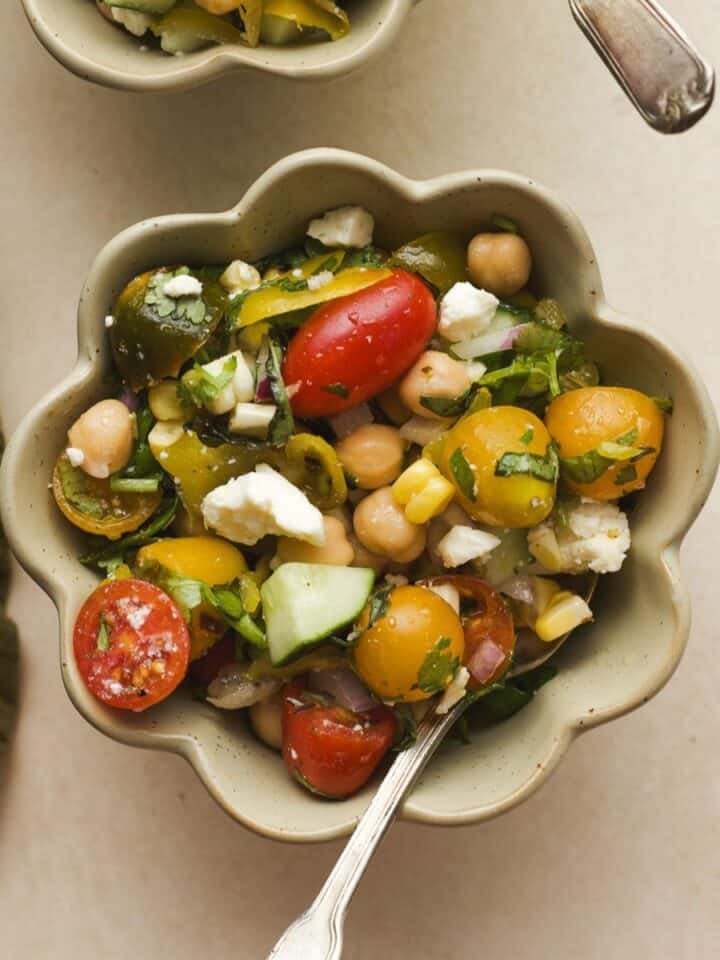 Summer chickpea salad with feta and tomatoes in a bowl.