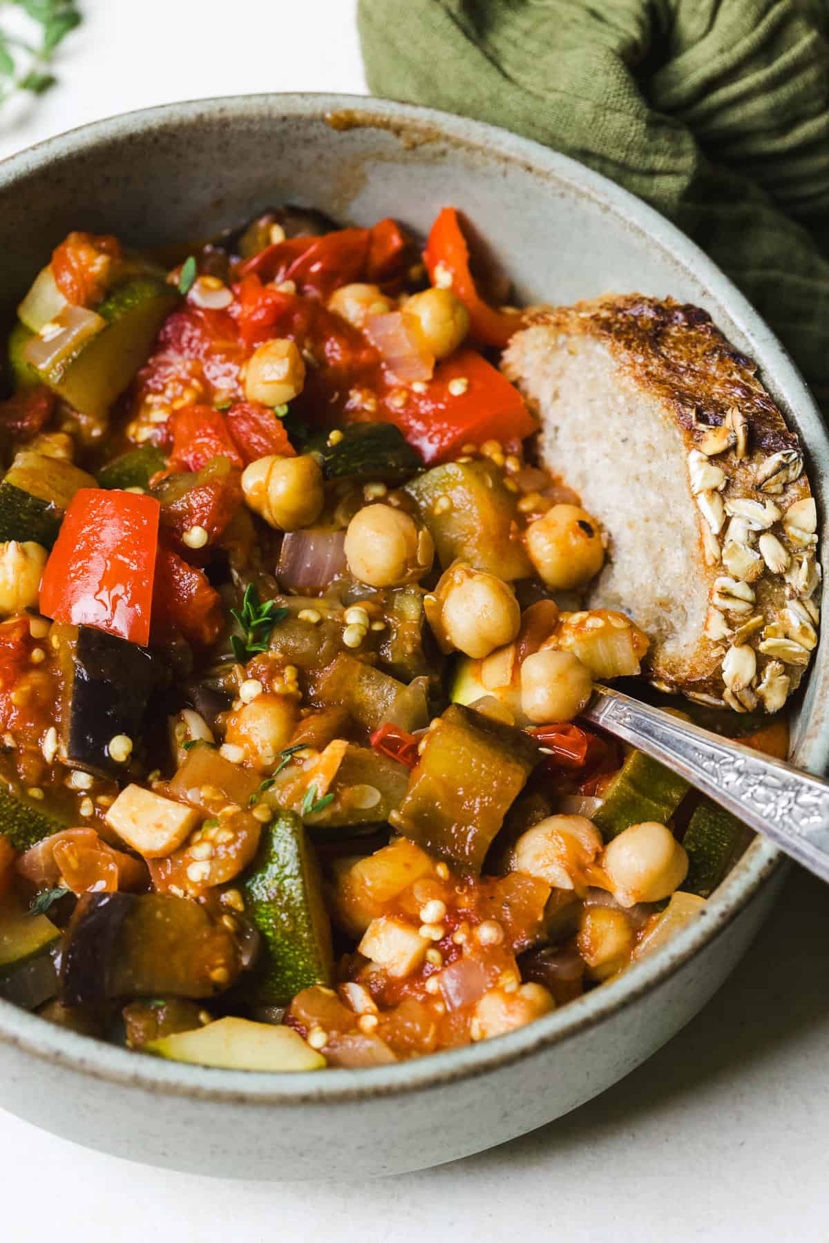 Easy ratatouille in a bowl with a slice of bread.