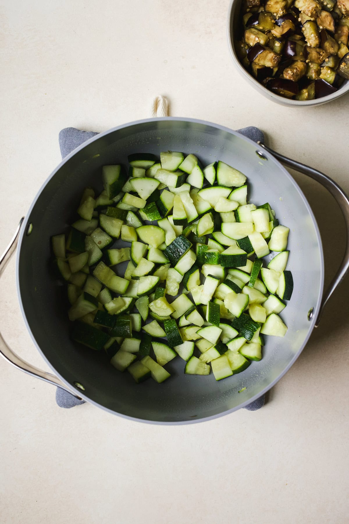 Sautéing zucchini cubes in a large pot.