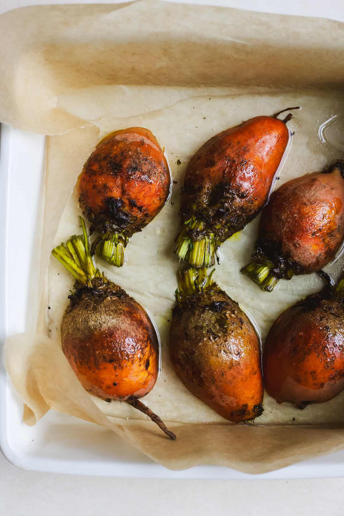 Seasoned golden beets in a pan before roasting.