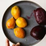 Fully peeled roasted golden beets and roasted red beets on a plate.