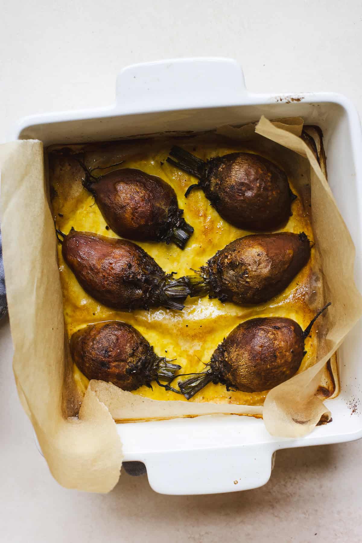 Roasted golden beets in a parchment lined pan.