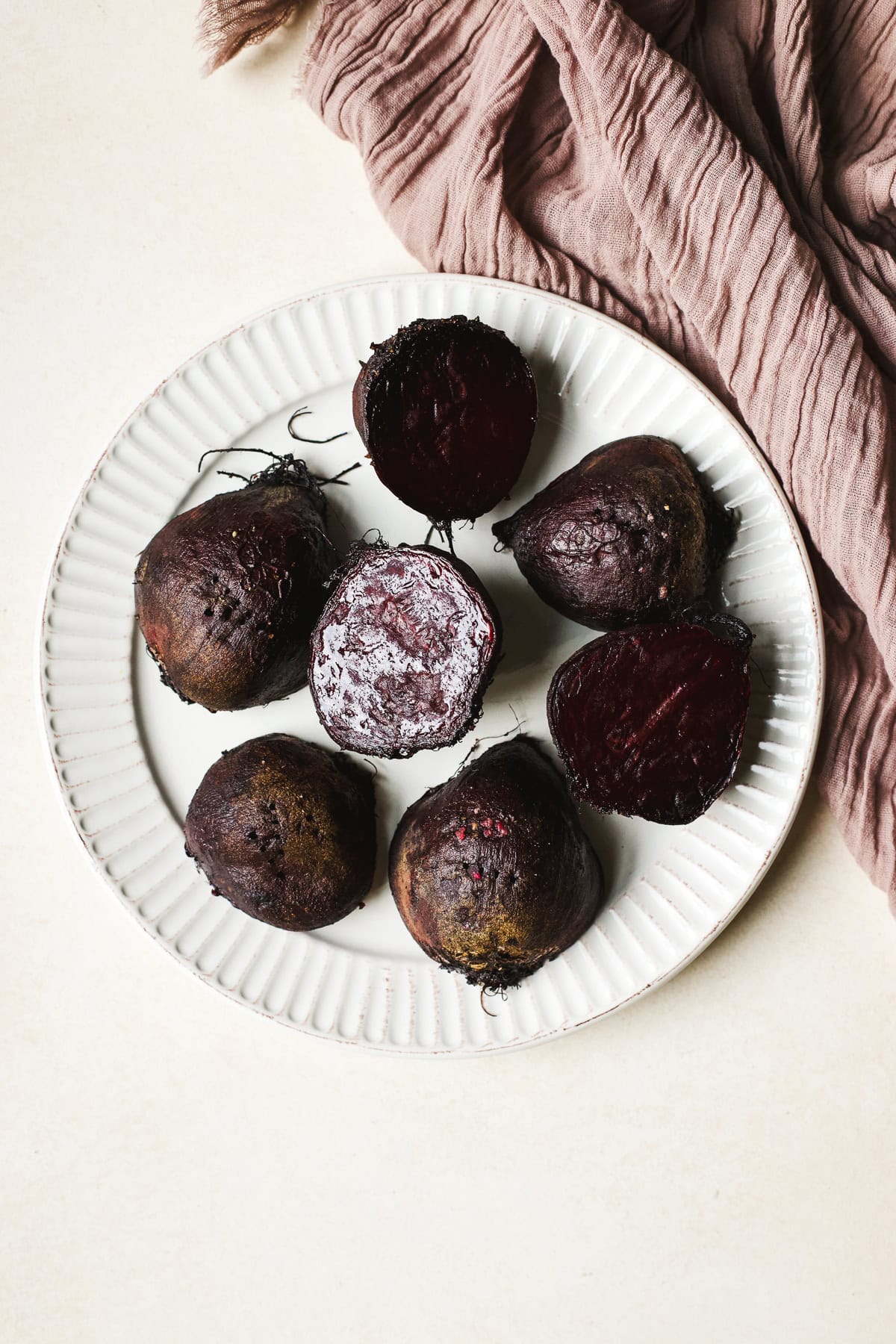 Roasted red beets in a plate before peeling.