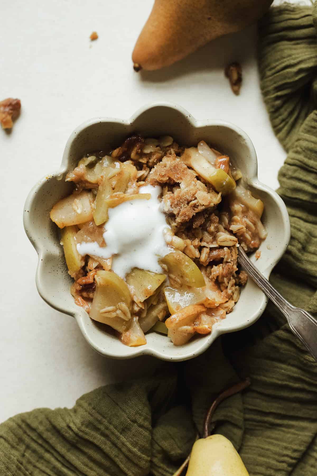 Easy apple pear crisp with oats and cinnamon, served warm in a small bowl with a scoop of vanilla ice cream.