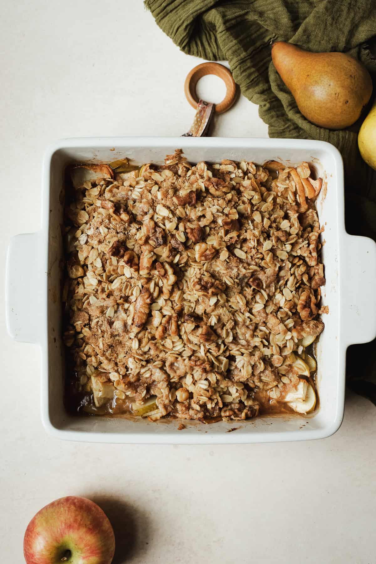 Fully baked apple pear crisp in baking dish with golden brown, buttery oat topping.