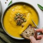 Dunking bread in a bowl of butternut squash soup with apple.