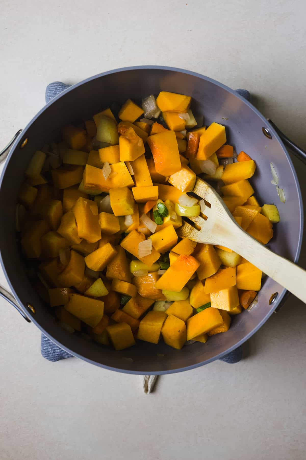 Sautéing aromatics and squash for a fall squash soup.