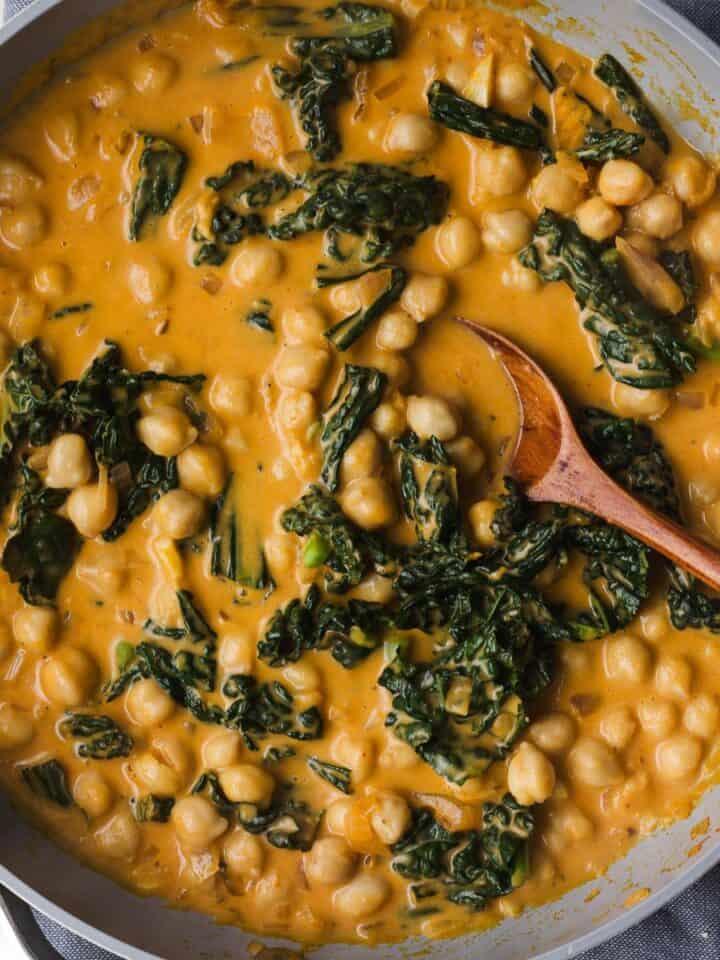 Creamy pumpkin curry with chickpeas in skillet.