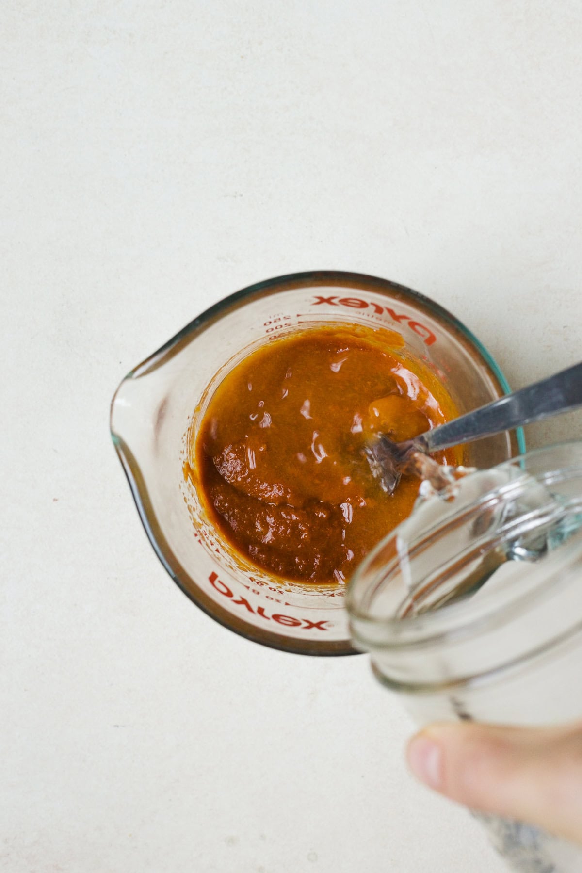 Adding water to Thai curry sauce.