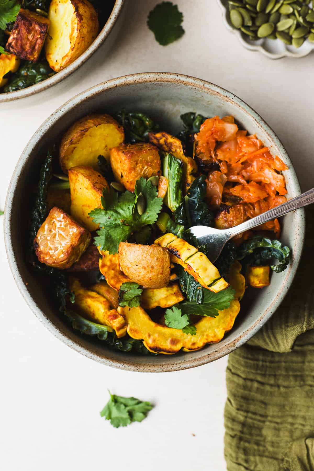 Miso curry delicata squash with tempeh in a bowl with kale.