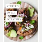 Three smoky black bean stuffed sweet potatoes with toppings on a plate.