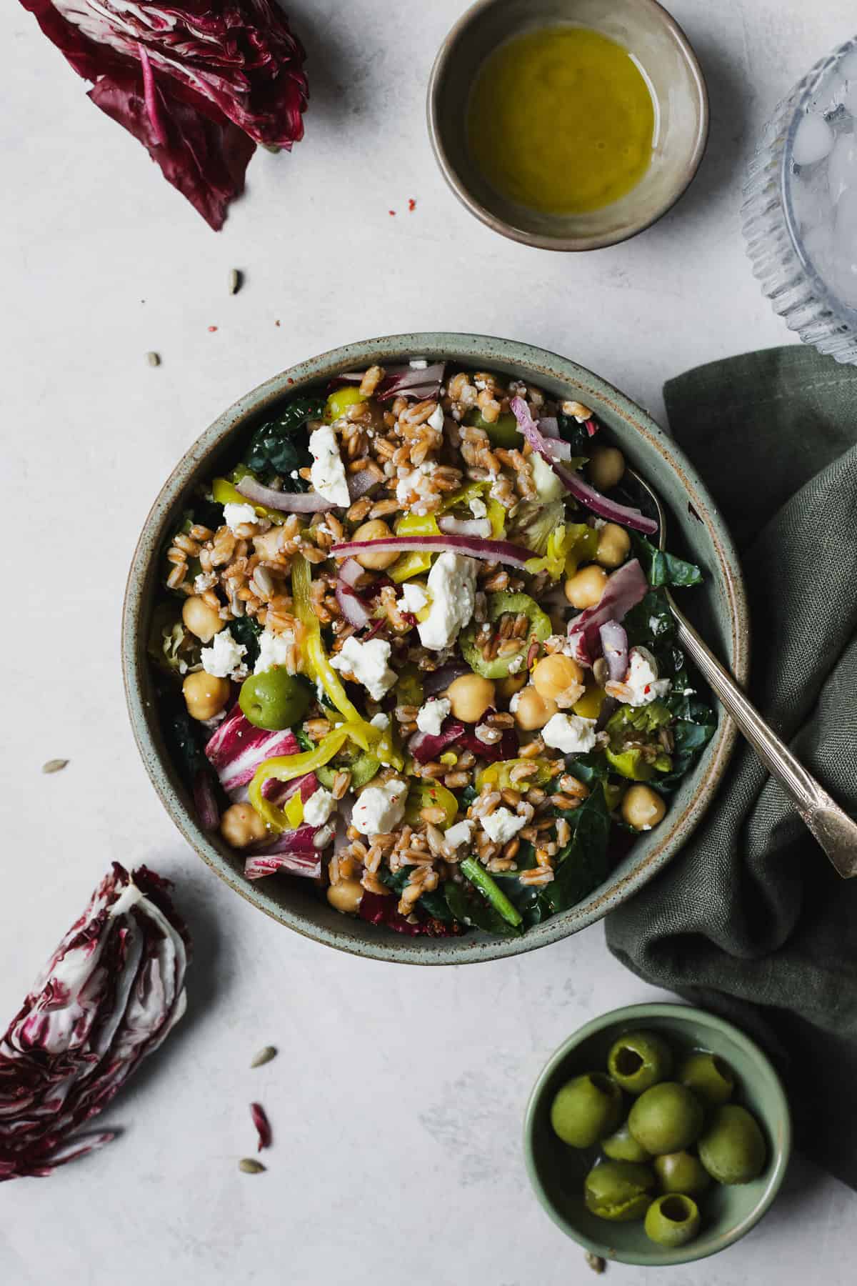Kale salad with farro and chickpeas in a bowl with a fork.