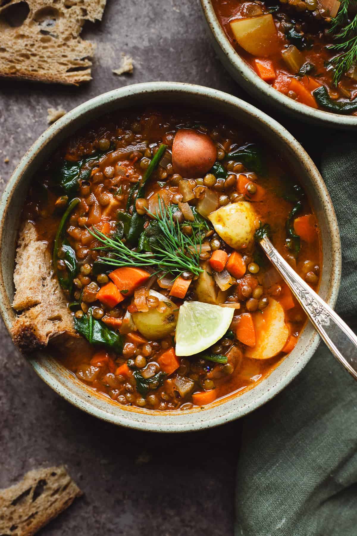 Lemony lentil soup with potatoes and fresh dill in a bowl.