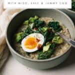 Savory oatmeal in a bowl topped with sautéed kale, jammy egg, and chili crisp.