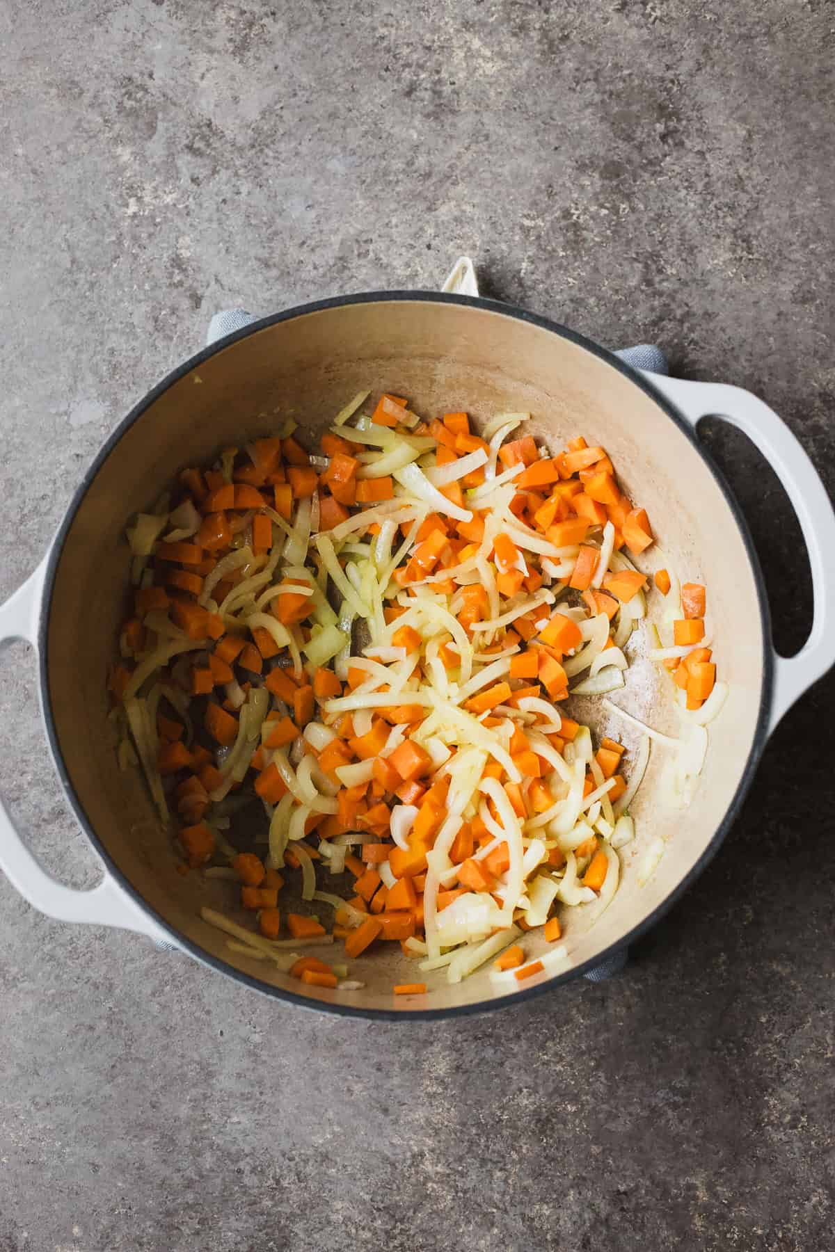 Sautéing onions, carrots, and garlic in large dutch oven.