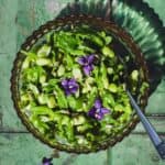 Snap pea and edamame salad in a bowl with fork.