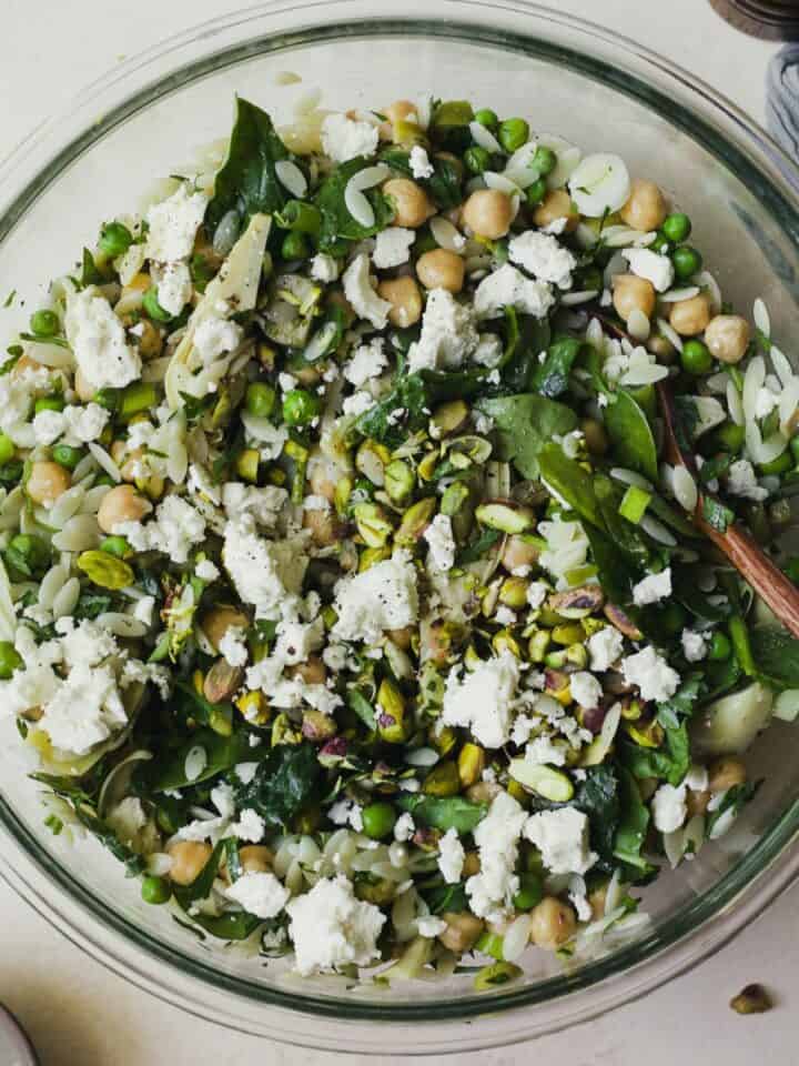 Herby orzo pasta salad with olives and chickpeas in a large bowl.