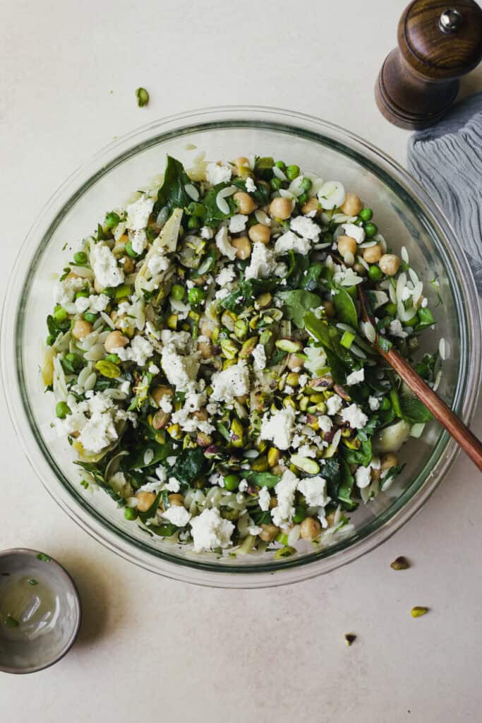 Herby orzo pasta salad with olives and chickpeas in a large bowl.