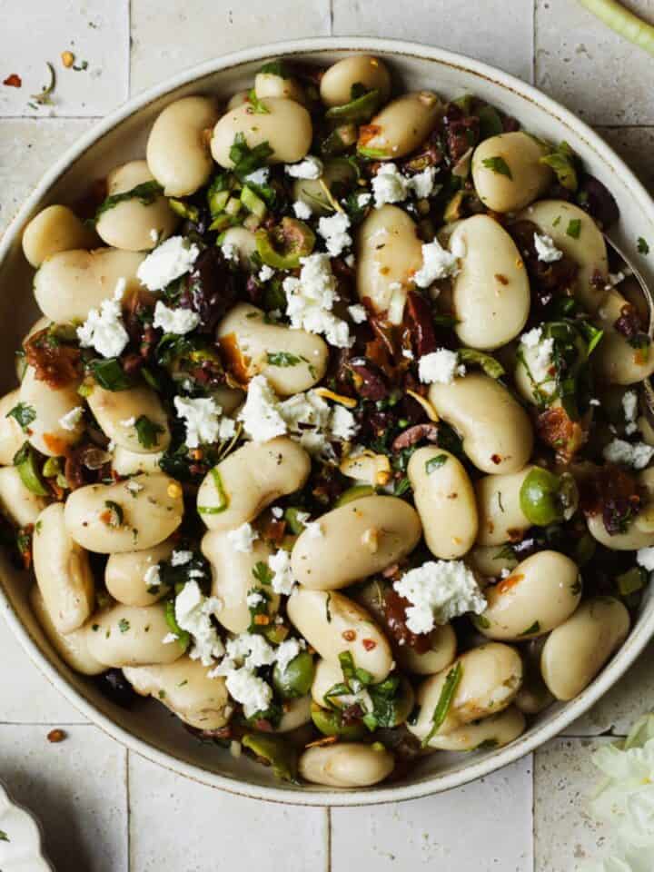 Marinated Royal Corona beans served in a bowl with a spoon.