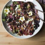 Cherry salad with wheat berries, feta, walnuts, and cherry vinaigrette in a serving bowl.