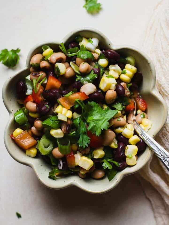 Black bean salad with sweet corn in a bowl with a spoon.