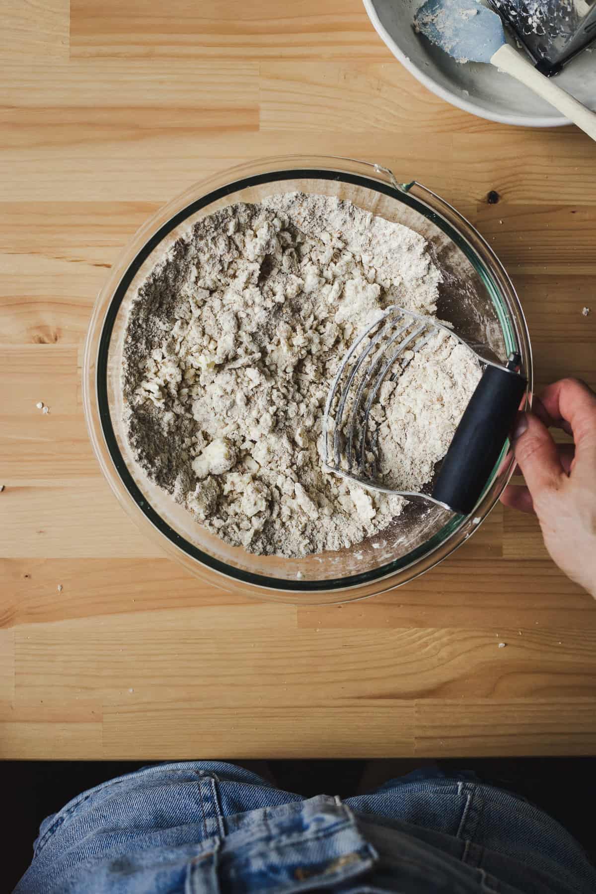 Grated butter cut into spelt flour mixture using a pastry cutter.