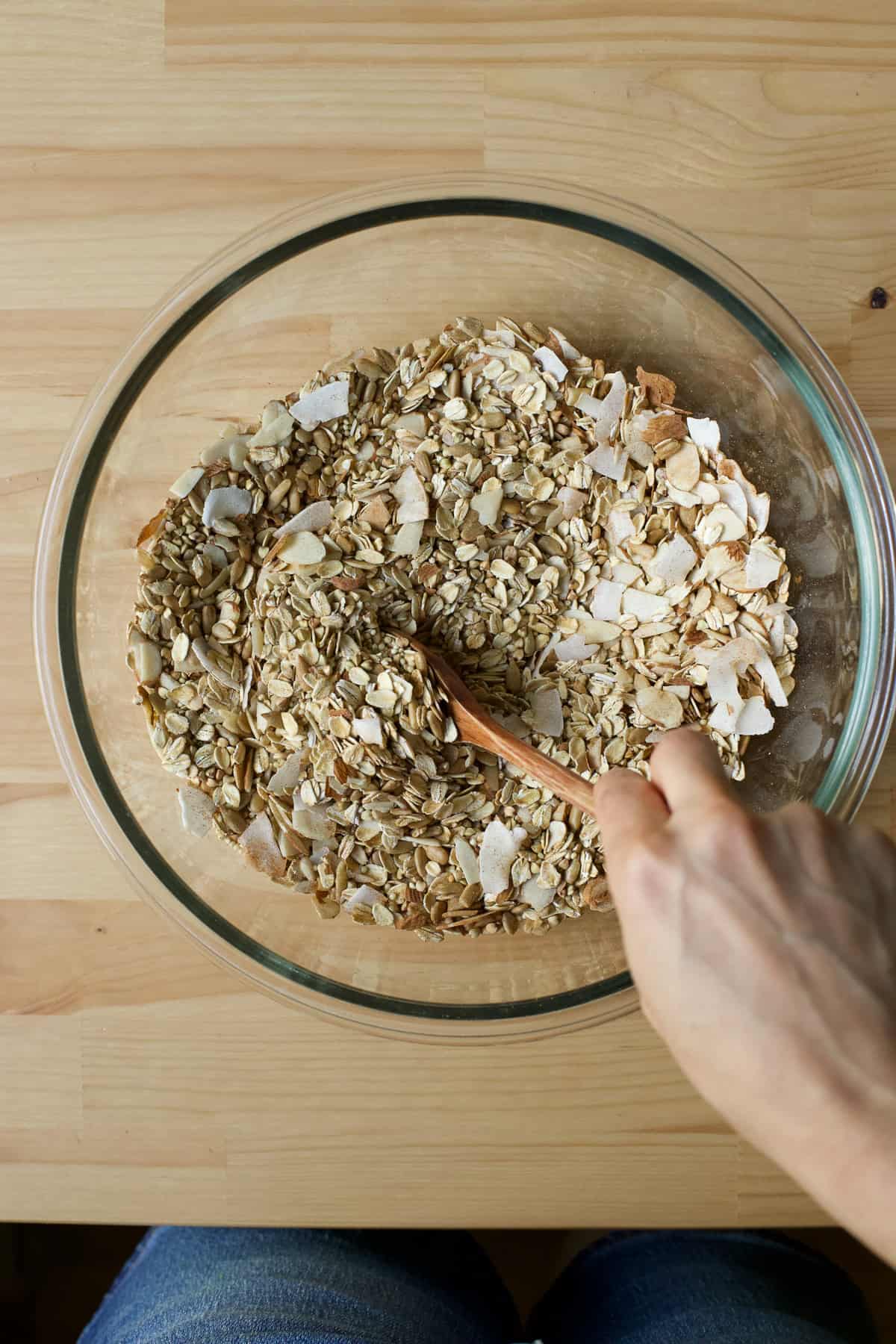 Mixing dry granola bar ingredients together in a bowl.