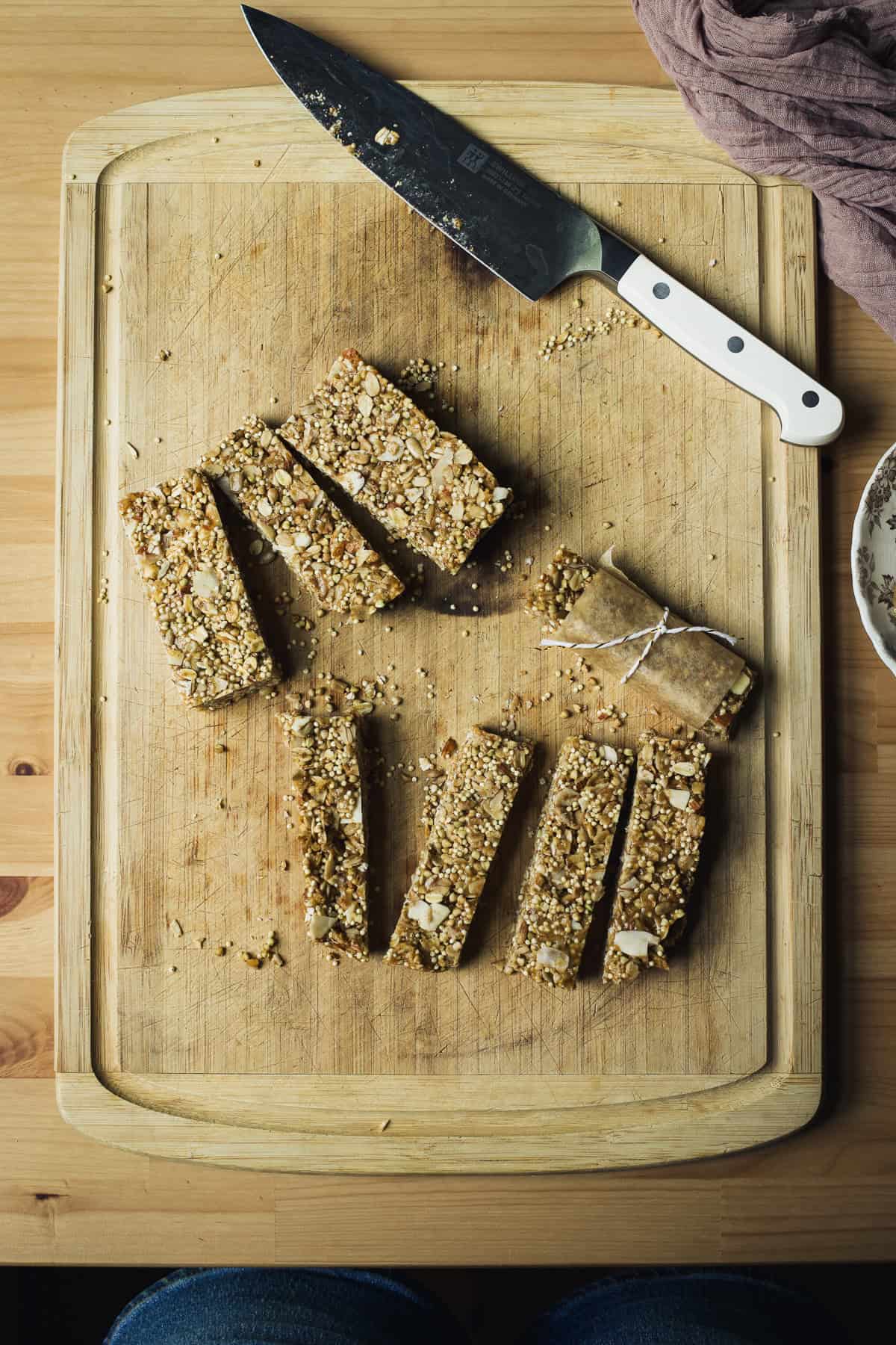 Cutting granola bars on a bamboo cutting board.