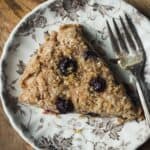 Lemon blueberry scone on a small plate topped with lemon sugar, with a fork.